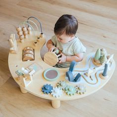 a baby playing with toys on a wooden table