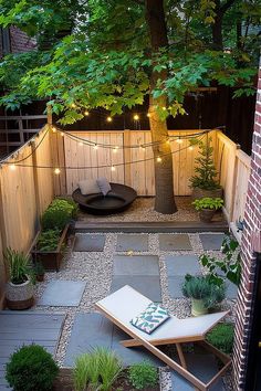 Cozy backyard with string lights, lush plants, wooden fencing, a modern lounge chair, and a circular seating area around a tree. Small Backyard With Garden, City Alleyway, Tree Landscaping