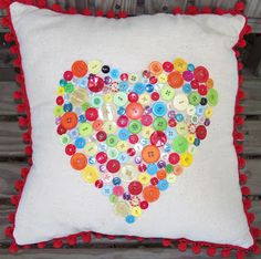 a heart made out of buttons on a pillow