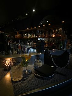 a dimly lit bar with drinks on the counter