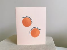 two oranges are shown on top of a card