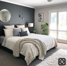 a bedroom with gray walls and white bedding