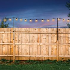 a wooden fence with string lights on it