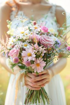 a woman holding a bouquet of flowers in her hands