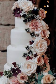 a wedding cake decorated with flowers and greenery