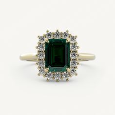 an emerald and diamond ring on a white background