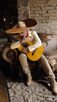 a man with a cowboy hat playing the guitar