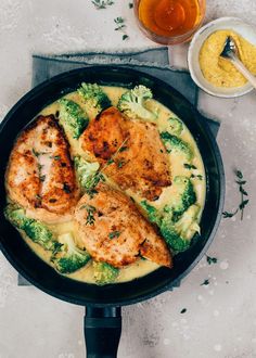 chicken, broccoli and cheese in a skillet next to a glass of beer