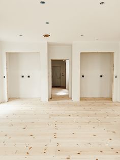 an empty room with white walls and wood flooring in the middle is being renovated