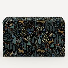 a black box with an animal pattern on the front and sides, surrounded by trees