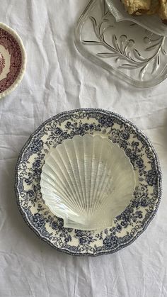 three plates with designs on them sitting on a white table cloth next to each other