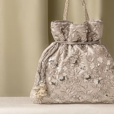 Silver Zardozi Sequin Flower Embroidered Satin Gray Wedding Potli Bag for Woman | Evening Cocktail Luxury Handcrafted Drawstring Purse Bag Size  : 10 x 8 Inches Package Content : 1 Pcs Designed with the heart, this beautiful Potli or batawa bag are eye catchy and made of premium material. Key Features: Embroidery art work This potli is good match with both Indian and western outfits and are superb for wedding and festive parties This would be best complement to your designer saree, lenhga or any other kind of dress This is the combination of traditional and modern embroidery work This is enough to keep your accessories and all needed essentials and it can be a best gift for any woman. Elegant Embroidered Fabric For Wedding, Elegant Embroidered Fabric For Wedding With Tonal Embroidery, Elegant Tonal Embroidered Fabric For Wedding, Elegant Wedding Fabric With Tonal Embroidery, Elegant Silver Embroidered Bags, Festive Embroidered Beige Evening Bag, Festive Beige Embellished Evening Bag, Silver Embroidered Bags Suitable For Gifts, Traditional Silver Bag For Reception