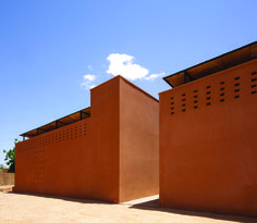 an adobe building with perfored windows on the side