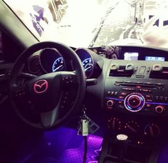 the interior of a car with purple lighting