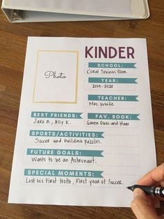 a person is writing on a paper next to a binder that has the words kinder written on it