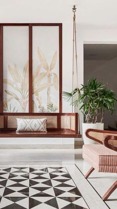 a living room filled with furniture next to a plant and potted plants on the wall