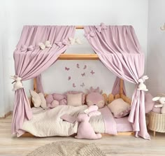 a child's bedroom with pink bedding and curtains