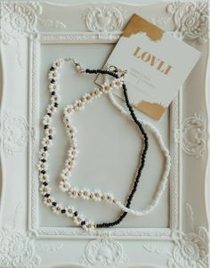 a beaded necklace is displayed in a white frame with a card on it that says i love you