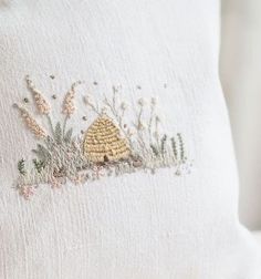 a close up of a white pillow with embroidered designs on the front and back of it