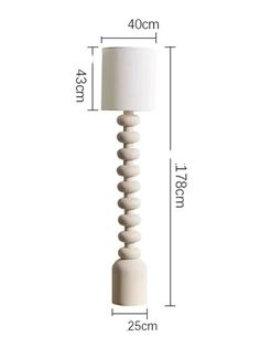 a white lamp that is on top of a wooden stand with measurements for the base