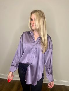 An opulent, long-sleeved satin top fashioned with a button-down front and an elegant oversized silhouette. Complete with alluring side slits that add a touch of flair and sophistication. Get ready for Game Day, Rush Week, Lake Life, Beach Day, Backyard BBQ, and Festival with this gorgeous satin top! Pair with our Maddie Jeans or your favorite skirt! Fabric: 100% Satin Fit: Oversized Model: Madison and SaraSize: Small Rush Week, Skirt Fabric, Satin Blouses, Purple Satin, Backyard Bbq, Purple Top, Satin Top, Oversized Silhouette, Lake Life