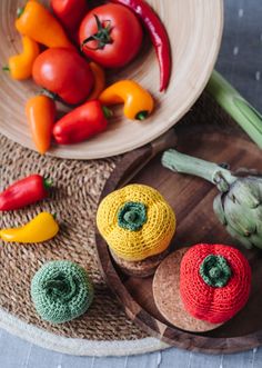 there are many different vegetables on the wooden tray and in the bowl they are crocheted