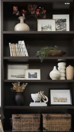 a bookshelf with baskets and pictures on it