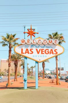 the welcome to las vegas sign in front of palm trees