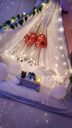 a bedroom decorated with balloons and lights for valentine's day or other special occasion