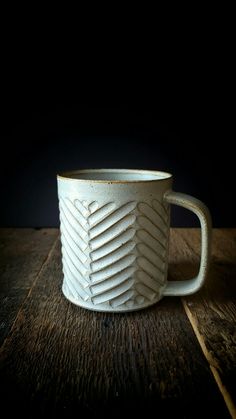 a white coffee cup sitting on top of a wooden table