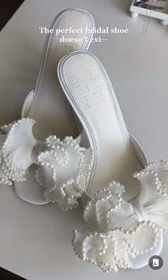 a pair of white shoes with pearls on them