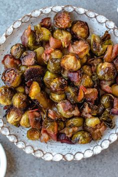 brussel sprouts with bacon in a white bowl on a gray table