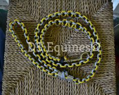 a yellow and black chain on top of a wicker bag