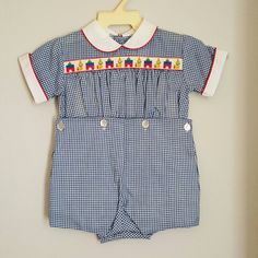 - This adorable outfit by C.I. Castro and Co. is perfect for any occasion. It is 2 pieces and navy blue gingham with a white collar piped in red. Across the chest is a retro ribbon with clowns and blocks. It buttons down back and snaps between legs. Sizes are: 9 months (21 available) 12 months (3) Fitted Short Sleeve Sets For Playtime, Fitted Cotton Sets For Playtime, Cute Fitted Gingham Sets, Fitted Blue Playtime Sets, Blue Cotton Patchwork Sets, Cute Fitted Playtime Sets, Summer Gingham Sets For Playtime, Summer Gingham Playtime Set, Fitted Plaid Sets For Spring