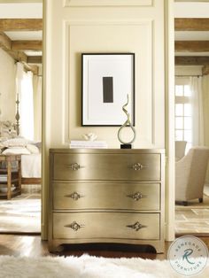 a gold dresser in a living room with white fur rugs on the wooden floor