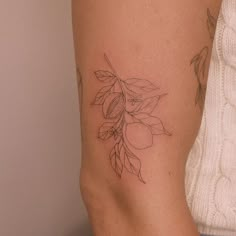 a woman's arm with a tattoo on it that has flowers and leaves growing out of it