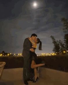 a man and woman are kissing in the moonlight