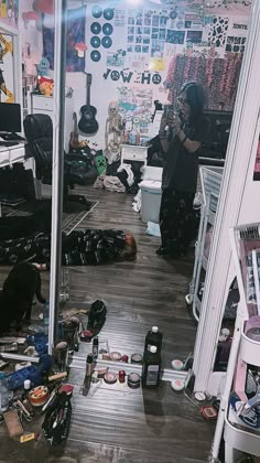 a room filled with lots of clutter next to a guitar and other musical instruments