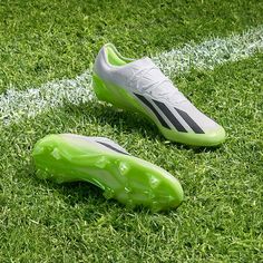 a pair of soccer shoes sitting on top of a green field