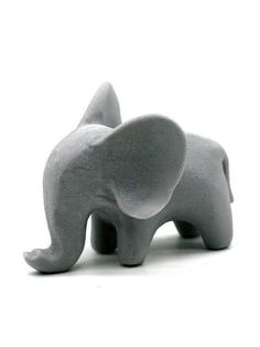 an elephant figurine sitting on top of a white surface