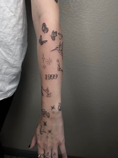 a woman's arm with tattoos on it and the number 999 written in black ink