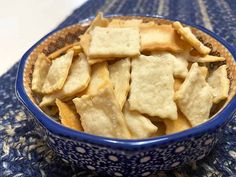 a blue bowl filled with crackers on top of a table