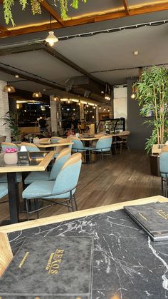 an empty restaurant with blue chairs and tables