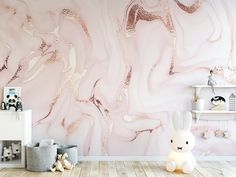 a pink and gold marble wallpaper in a child's room with a teddy bear