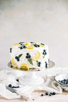 a white cake with blueberries and lemons on top