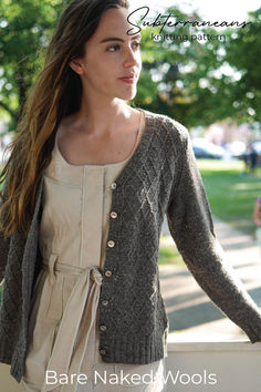 a woman is standing outside wearing a cardigan