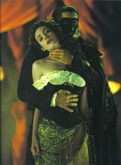 a man and woman dressed in costumes hugging each other while standing next to each other