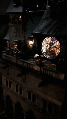 a clock on top of a building at night with light coming from it's windows