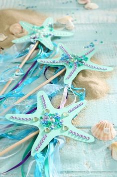 several starfish and seashells on the beach with blue streamers, sand and shells