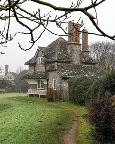 an old house with a bench in front of it on a foggy, overcast day